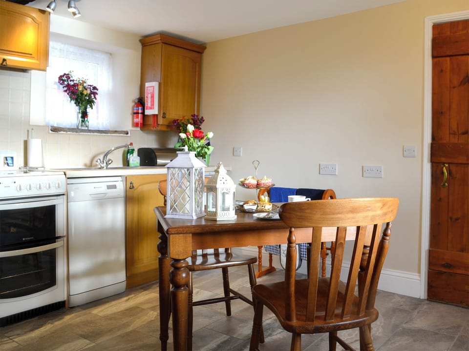 Kitchen and dining area with open fire | Buckswell Cottage, Baldersdale, near Barnard Castle