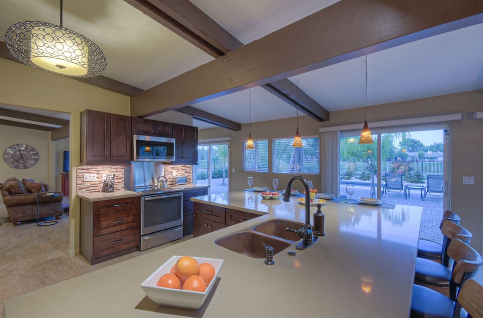 Windows and sliding doors extending along the back of home allow natural light to brighten living spaces.