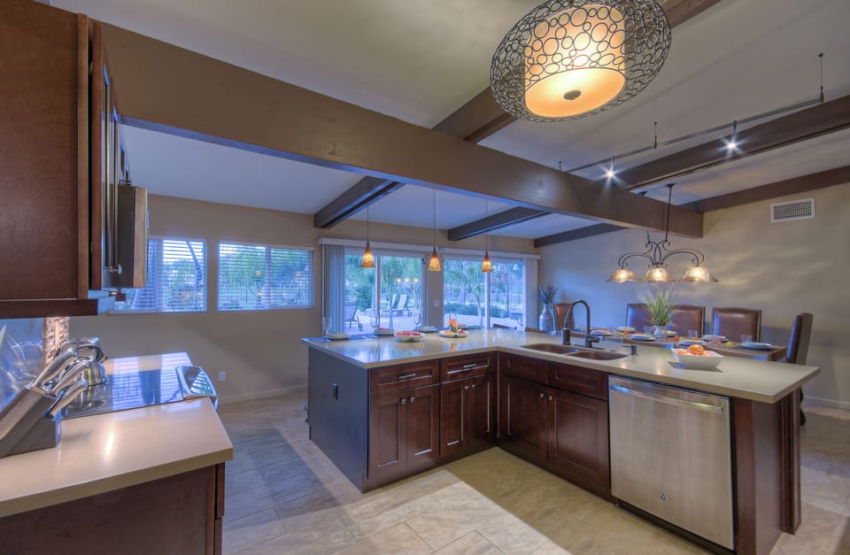 Workspace in kitchen is well lit and designed to be efficient for preparing and serving delectable cuisine.