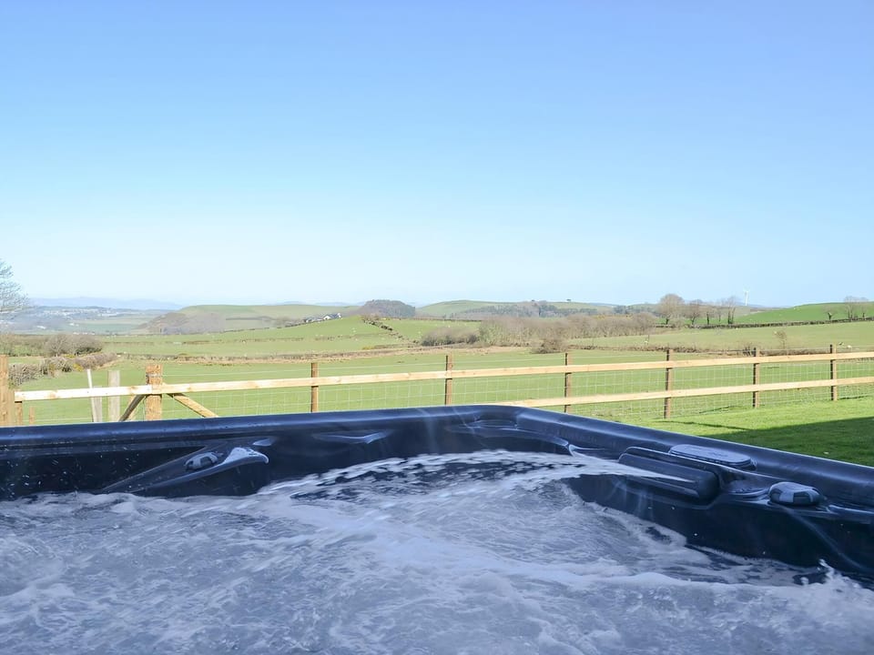 Soak up the glorious Welsh sunshine whilst relaxing in the hot tub | Bryncrwn Cottage, Llanfarian, Aberystwyth