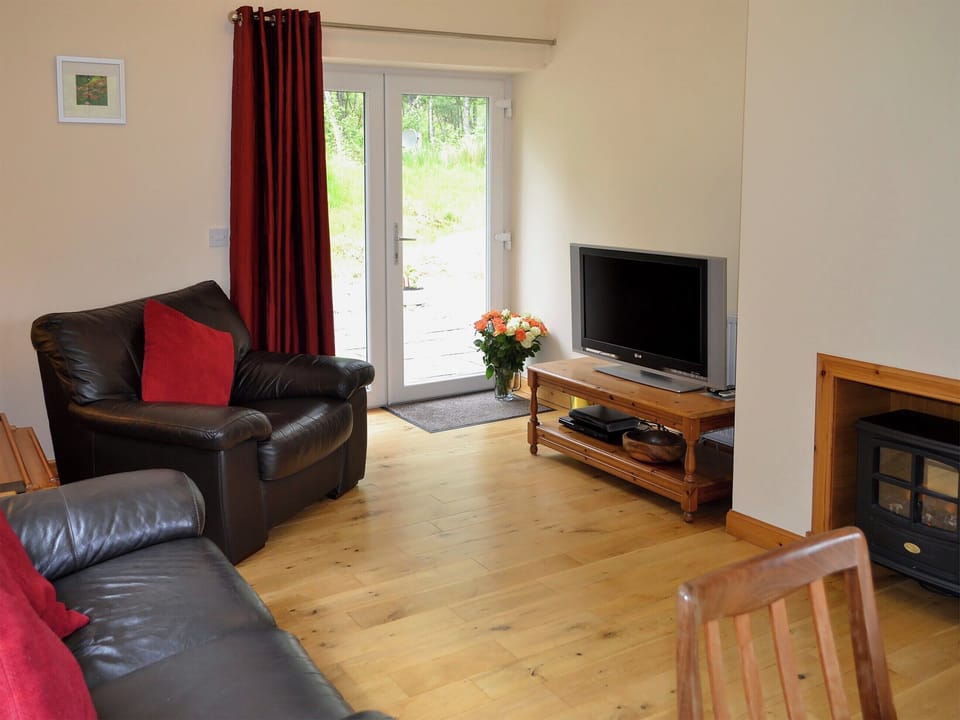 Spacious living/dining room with electric woodburner and wooden floor | Laundry Cottage, Ceannacroc
