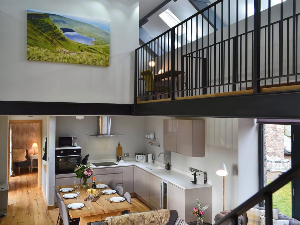 Open plan living space with beams and oak floors | Maes Merlin, Llanddeusant, near Llangadog