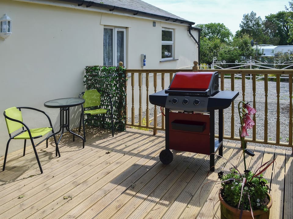 Delightful decked area for alfresco entertaining | Hunter&rsquo;s Cottage - Llwyn Ffynnon, Y Ff&ocirc;r, near Pwllheli