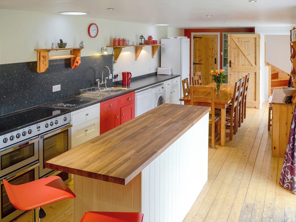 Farmhouse kitchen table, wood burner and bright, contemporary kitchen units with large range cooker | Kate&rsquo;s Croft, Gartymore, near Helmsdale