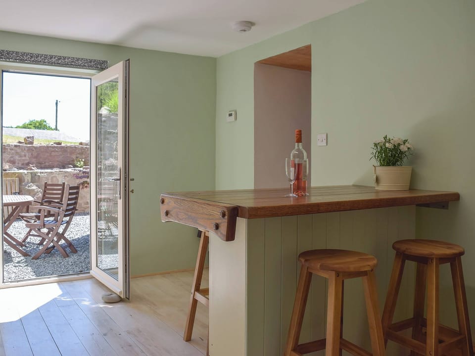 Spacious kitchen with breakfast bar and access to the garden | Woodlands, Laugharne, near Pendine