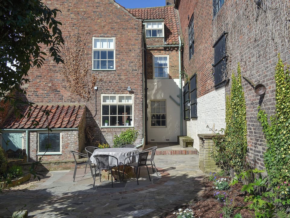 Private courtyard with table and chairs for al-fresco dining | Nell&rsquo;s Cottage, Bridlington