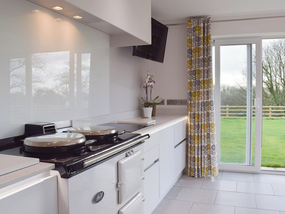 An Aga and sliding doors to the garden give the kitchen area a classical feel | Ivy Bush Cottage, New Moat, near Narberth