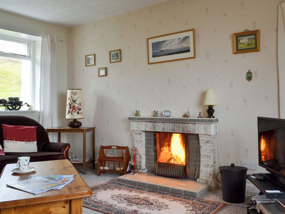 Comfortable living room with an open fire | Tigh Mairi, Carragrich, near Tarbert, Isle of Harris
