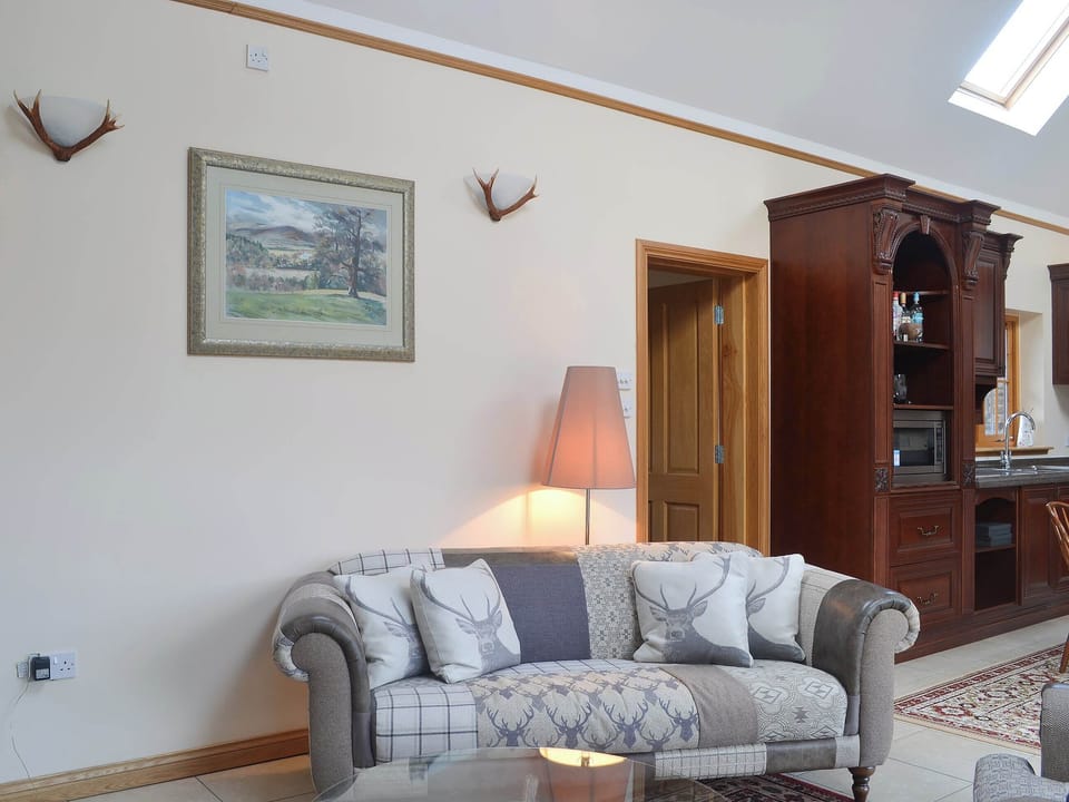 The open plan living area boasts a vaulted ceiling | Turin Nurin Cottage, Tomatin, near Inverness