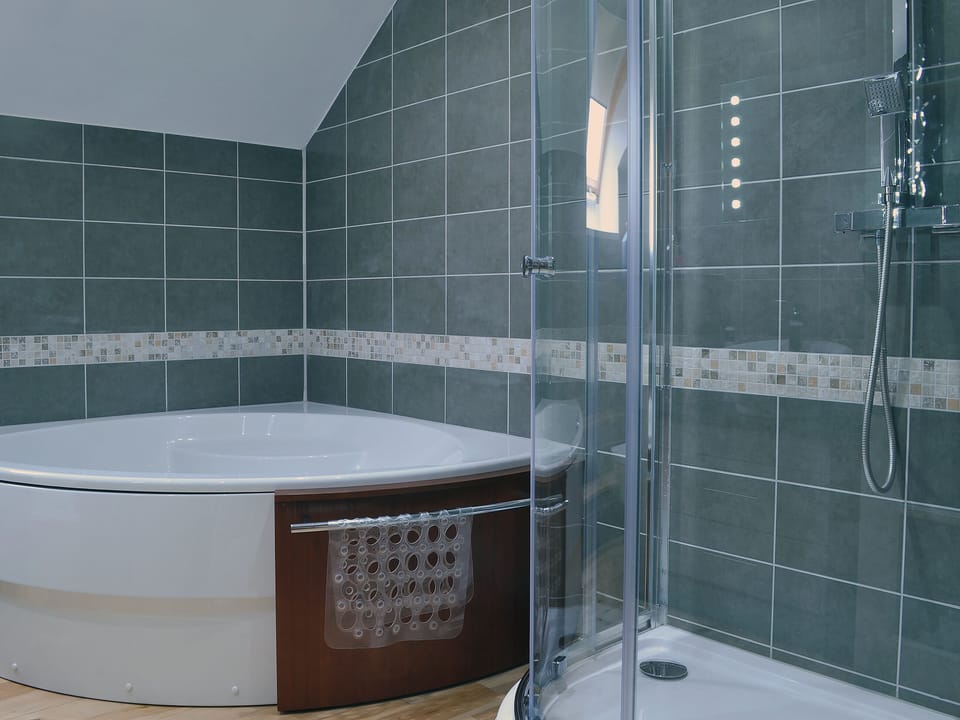Lovely bathroom with curved corner bath and standalone shower | The Loft - Lluest Cottages, Neuaddlwyd, near Aberaeron