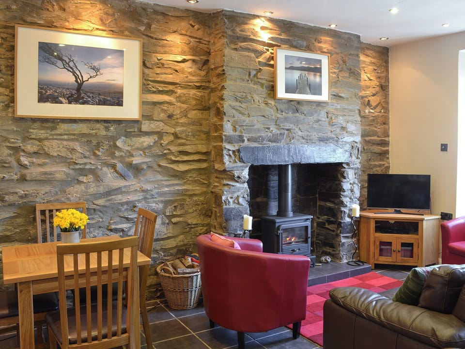 Living room with wood burner and dining area | Gwyrfai Cottage, Waunfawr, near Caernarfon