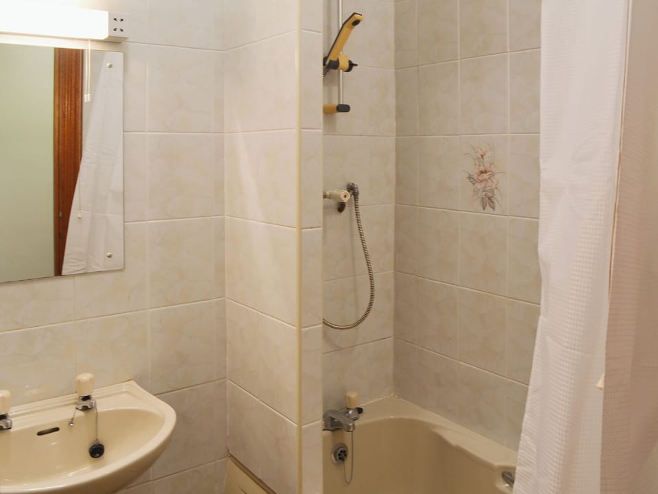 Bathroom with shower over the bath | Glan-Mor, Pwllheli