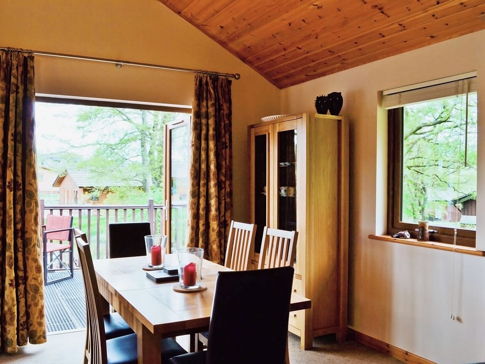 The dining table is next to a set of patio doors that open onto the terrace | Rowanburn Lodge, Greystoke, near Penrith