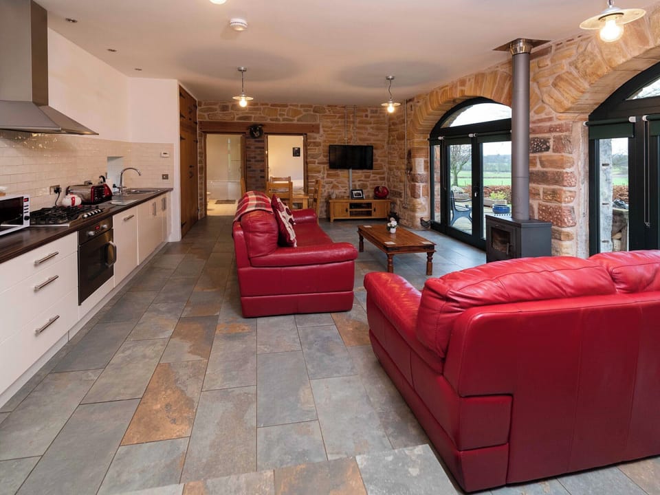 Cosy living area with wood-burning stove and large arched windows | Cart Shed, Mauchline, near Ayr