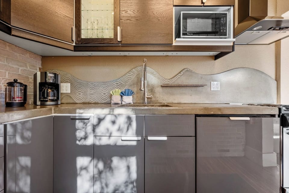 Fully stocked kitchen with custom concrete countertops, gas range, dishwasher