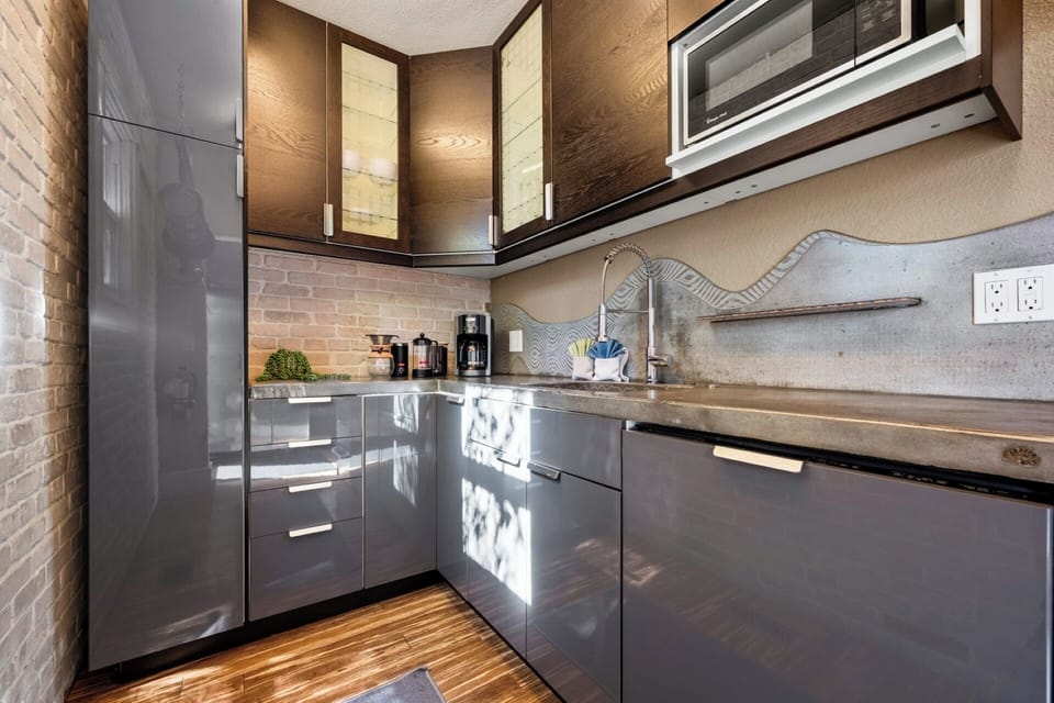 Fully stocked kitchen with custom concrete countertops, gas range, dishwasher