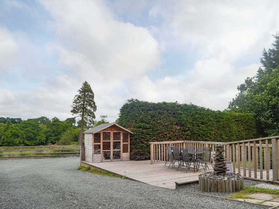 Summerhouse with table and chairs on the decking | Bevan House, Hundred House, near Builth Wells