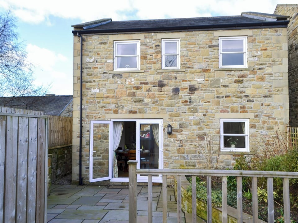Enclosed patio garden with decked area and garden furniture | Castle Holt, Otterburn, near Bellingham