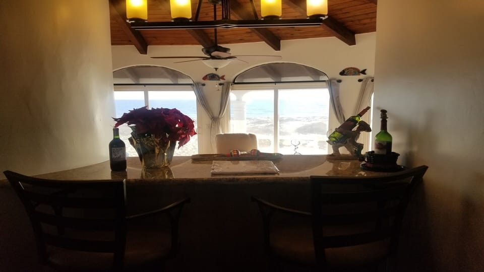 Cozy granite bar. Ocean view. Exposed rustic wood beams throughout.