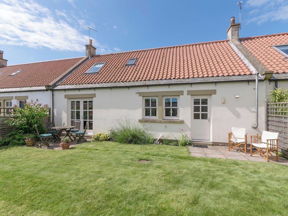 Rear garden with twin patio areas | Embleton Cottage, Beadnell