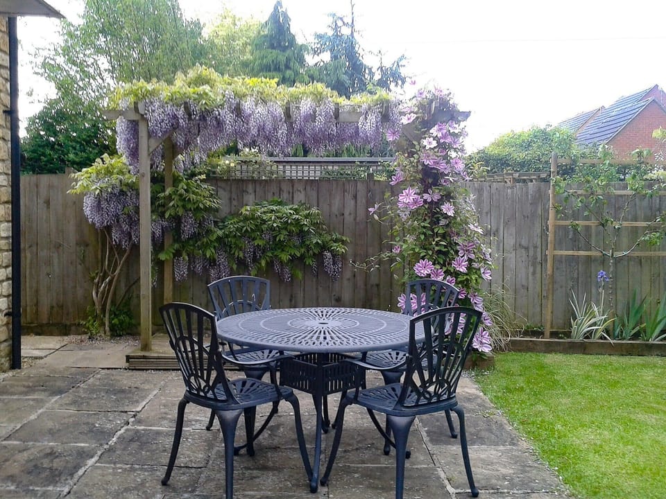Sunny paved patio with furniture | Russet Cottage, Moreton-in-Marsh