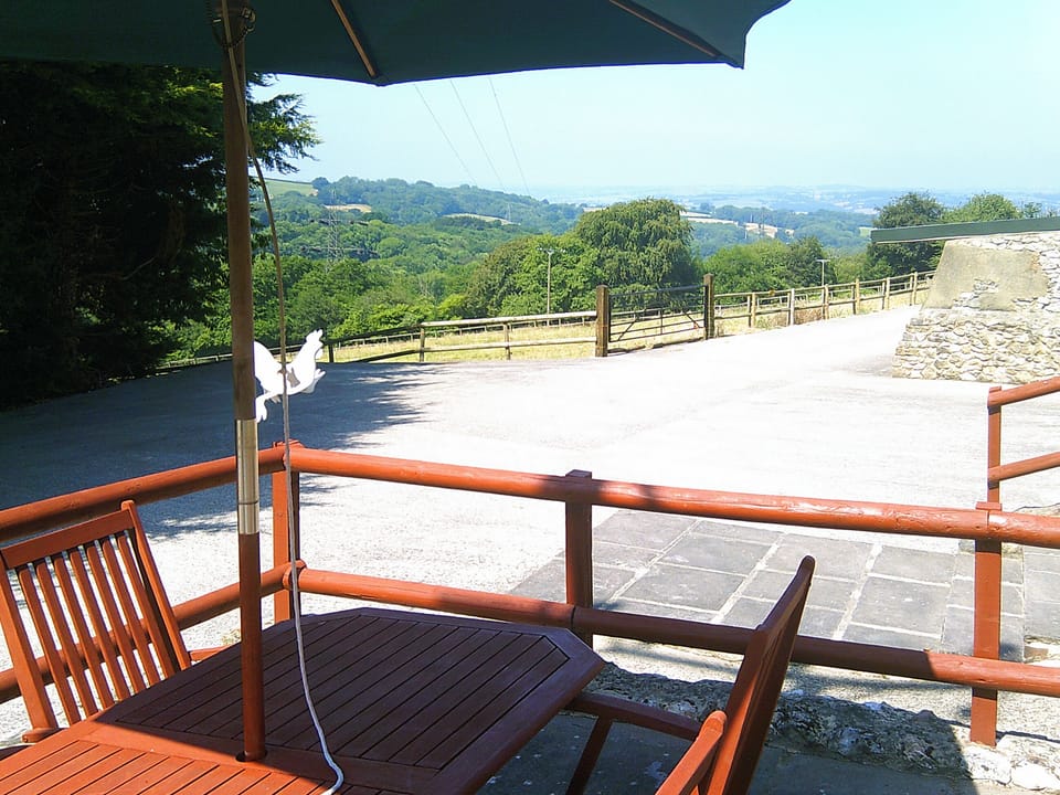 Enclosed raised patio with outdoor furniture | Cider Cottage - Higher Checkridge Farm, Hawkchurch, near Lyme Regis