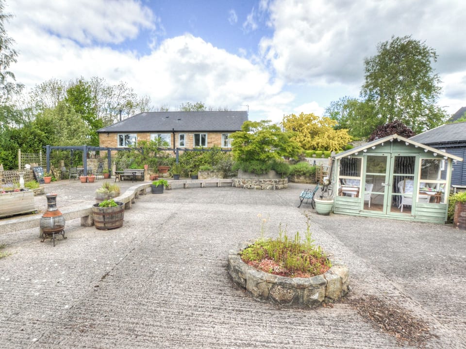 Patio area with summerhouse and cottage in the background | Hadrian&rsquo;s Garden Villa, Henshaw, near Haltwhistle