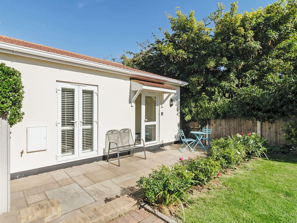 Enclosed lawned garden with terrace | Owls Croft, Broadstairs