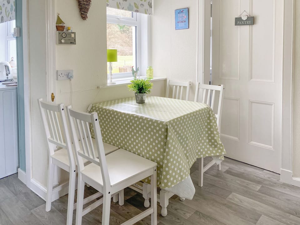 Bright dining area with extendable table which seats up to 6 people, leading through to quaint pantry which offers good storage area and compact kitchen | Kirnan Cottage, Kilmichael Glassary, near Lochgilphead