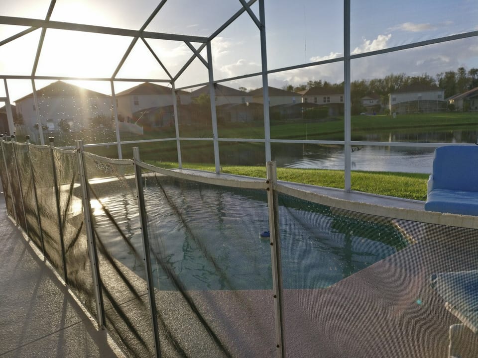 Pool area with safety screen and lake view