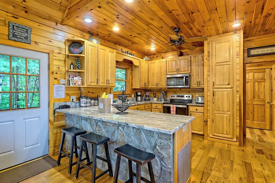 Kitchen with 3 barstools and door to front porch