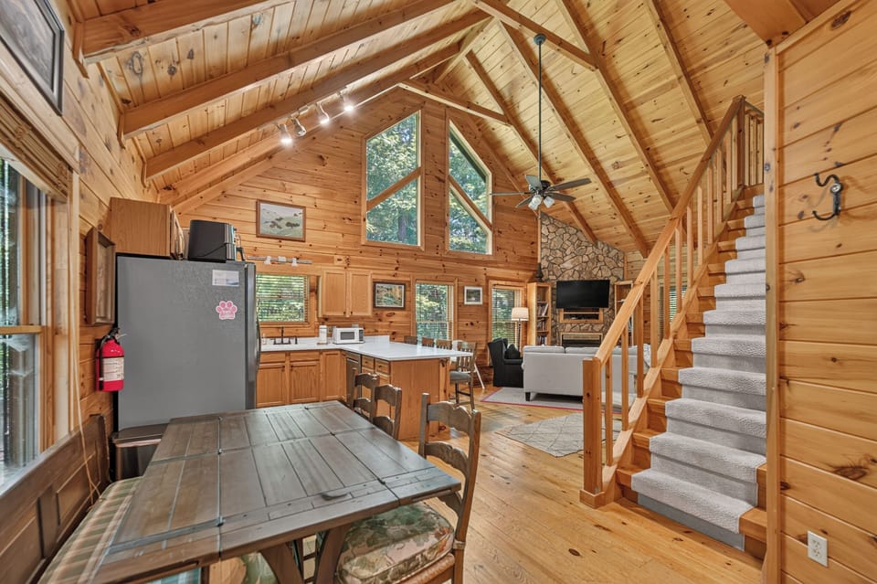 Charming cabin-style living area with vaulted ceilings and cozy stone fireplace.