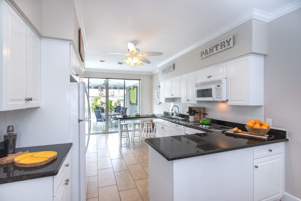 A view of the kitchen and the outdoor poolside dining area