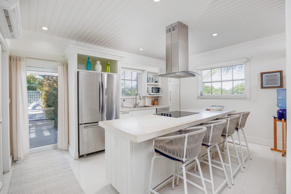 The fully equipped island kitchen features a gas range, stainless steel appliances, and decorative concrete counter tops