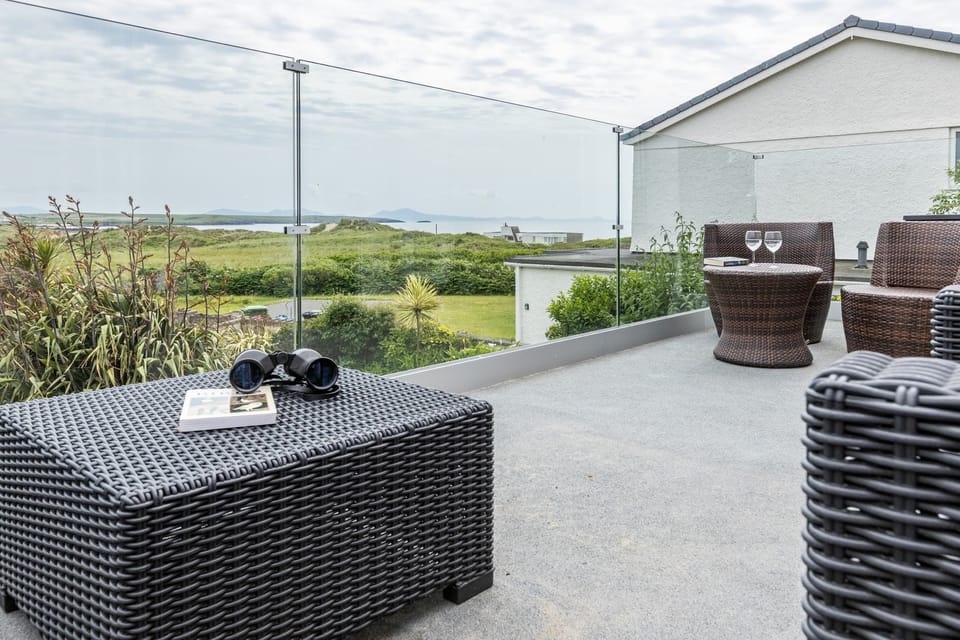Outdoor seating area with views, relaxing outdoor space at pet-friendly family holiday home in Rhosneigr, Anglesey
