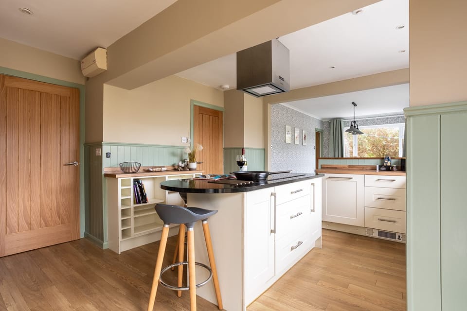 Kitchen island with bar seating, sociable cooking space at large pet-friendly holiday home in Rhosneigr, Anglesey