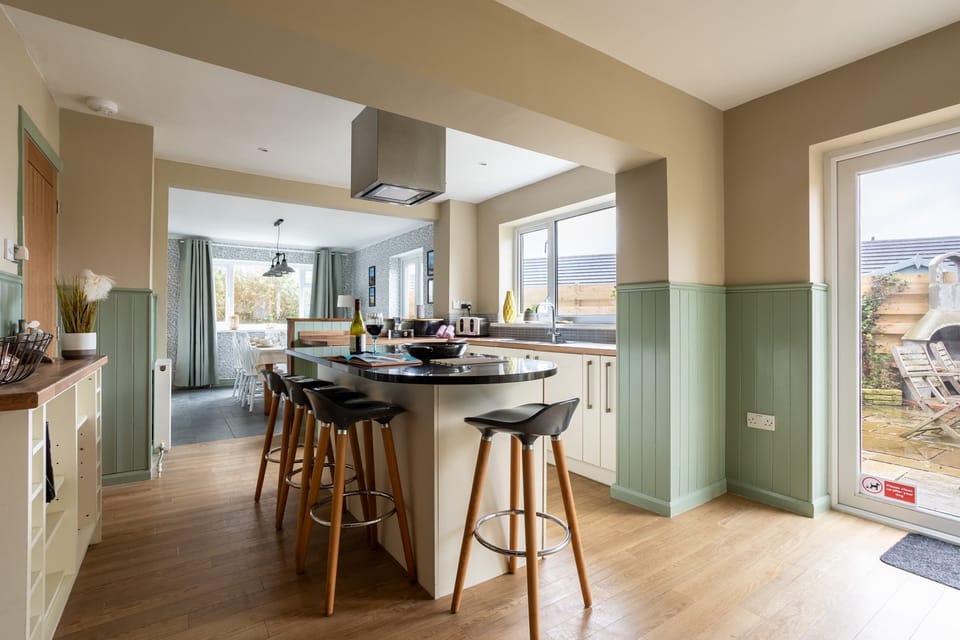 Stylish kitchen with central island breakfast bar, open-plan self-catering holiday home sleeping eight in Rhosneigr, Anglesey