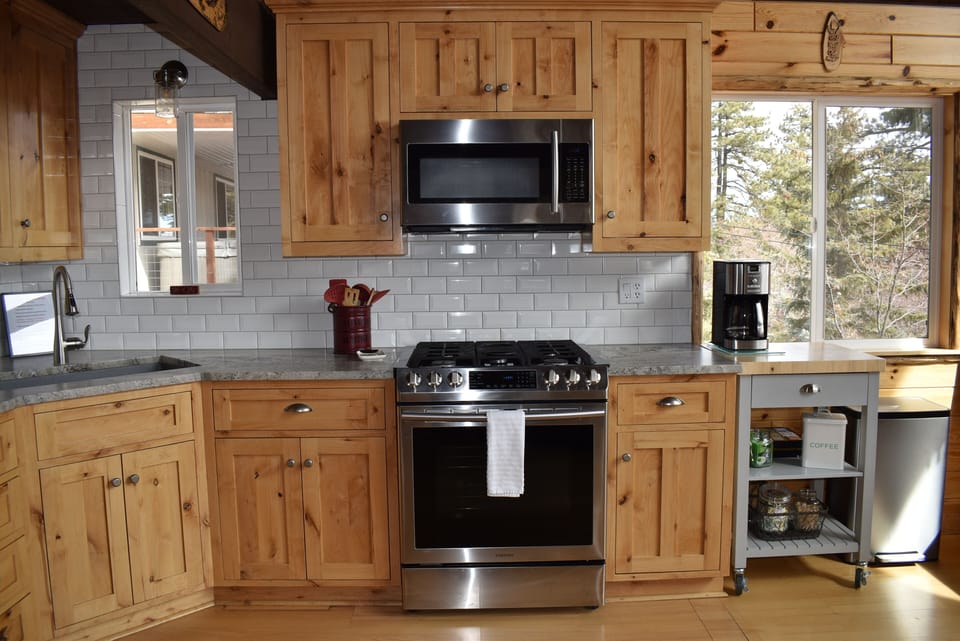 Fully stocked kitchen with microwave, oven and coffee maker.