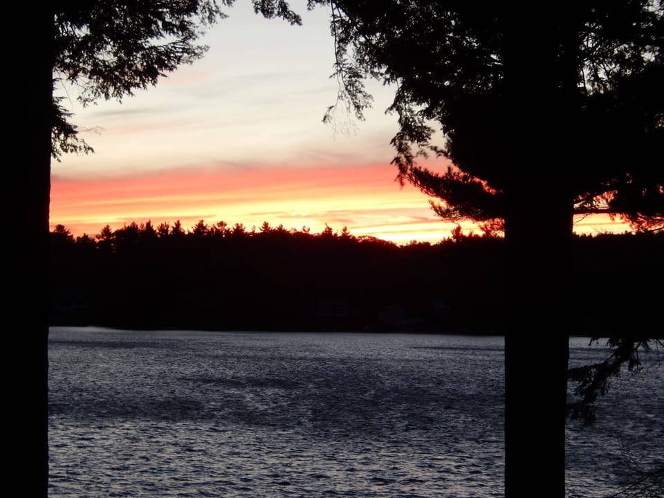 View of sunset over lake from deck.