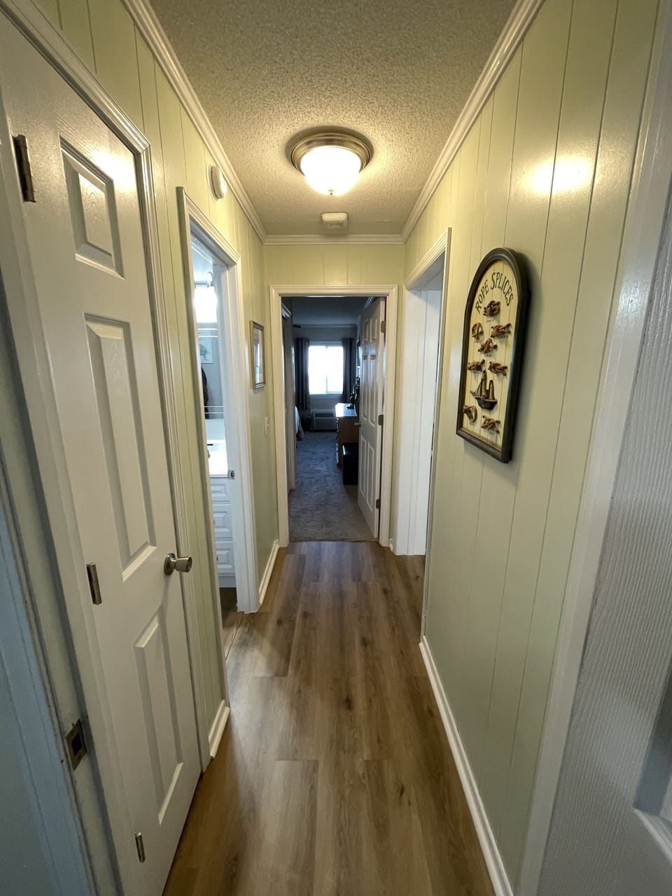 New flooring in hallway and paneled doors throughout the condo