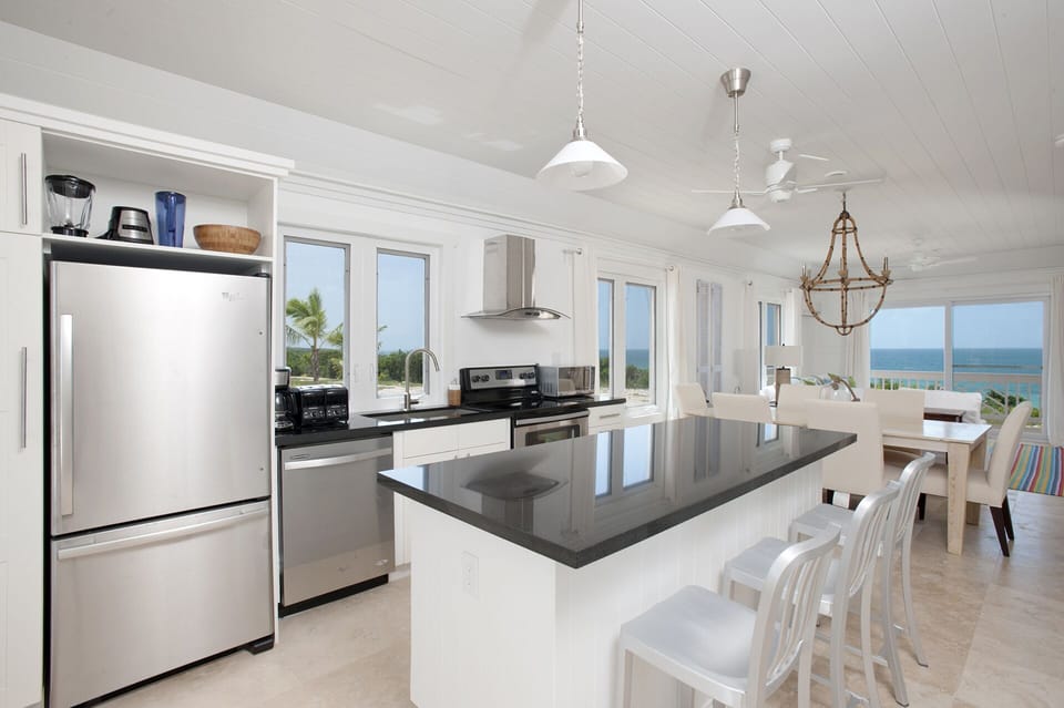 Modern kitchen in black granite and stainless steel, with views of both oceans.