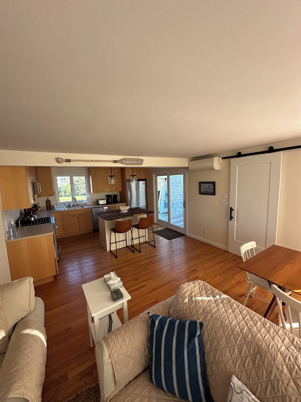 Newly added kitchen island and stools. Sliders to the expansive deck.