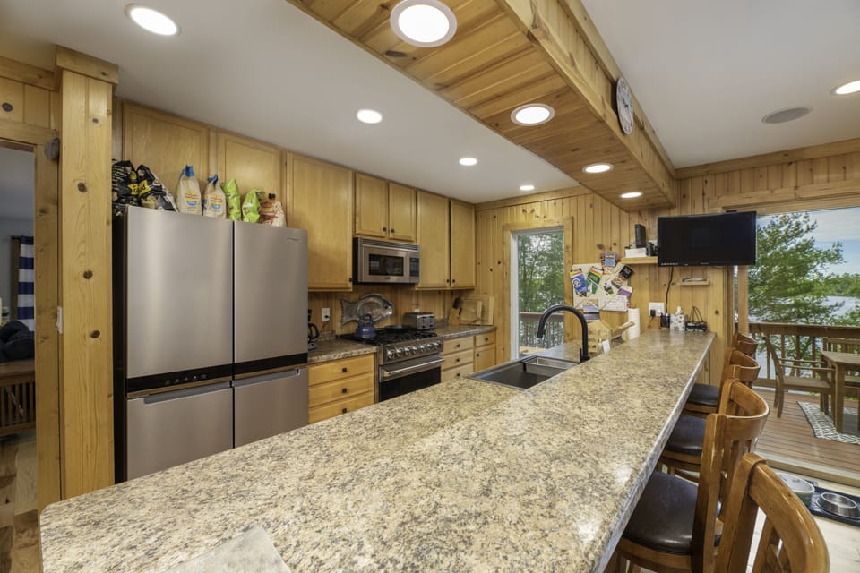 Well-stocked kitchen has Sonos, tv, & new sink, range, microwave, & fridge