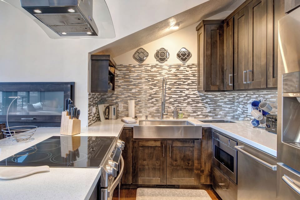 Fully Equipped Kitchen with Stainless Steel Appliances, including an Induction Electric Range, Quartz Counters and Bar Seating for Two