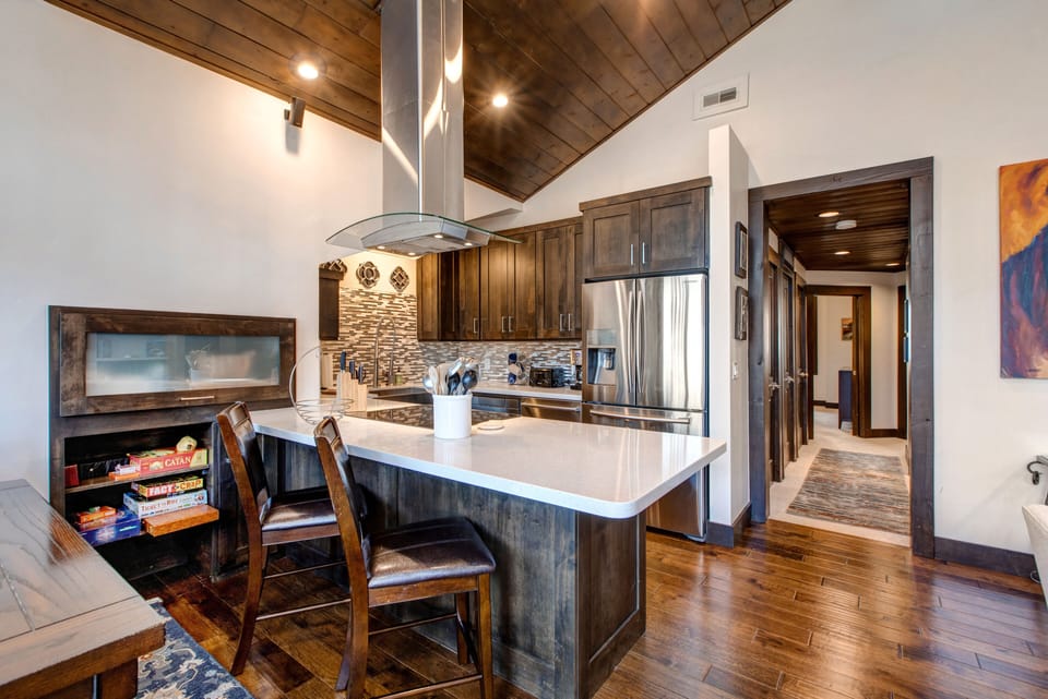 Fully Equipped Kitchen with Stainless Steel Appliances, including an Induction Electric Range, Quartz Counters and Bar Seating for Two