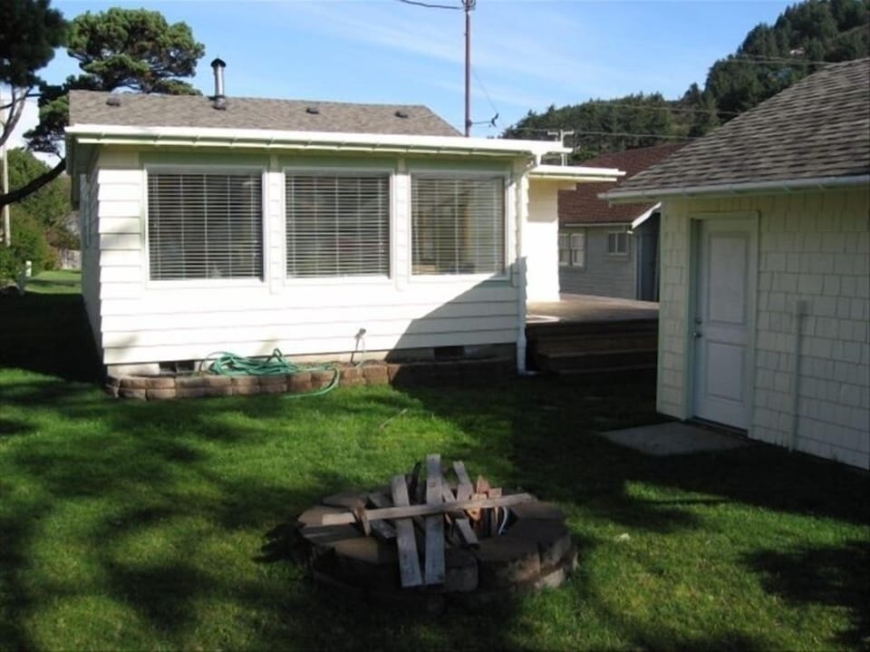 Facing back of house/picture windows in Den/Sun room.  Fire pit in foreground