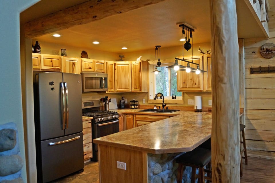 Cook like a chef in this modern kitchen. GE Slate appliances and designer lights