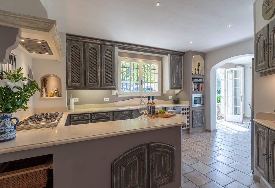 Beautifully-decorated country kitchen, modern appliances with adjacent laundry