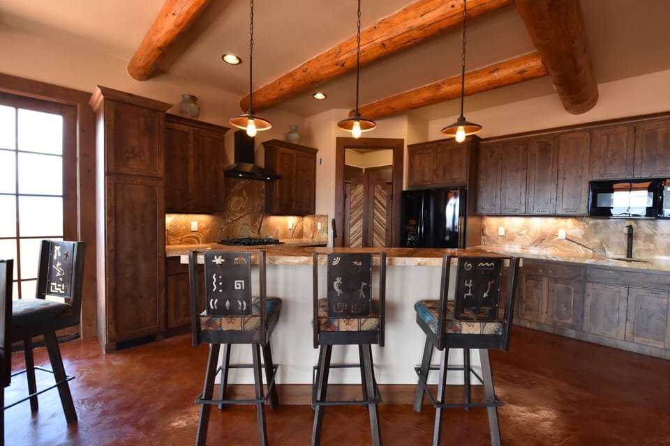 Raised kitchen bar allows friends and family to socialize while preparing meals.