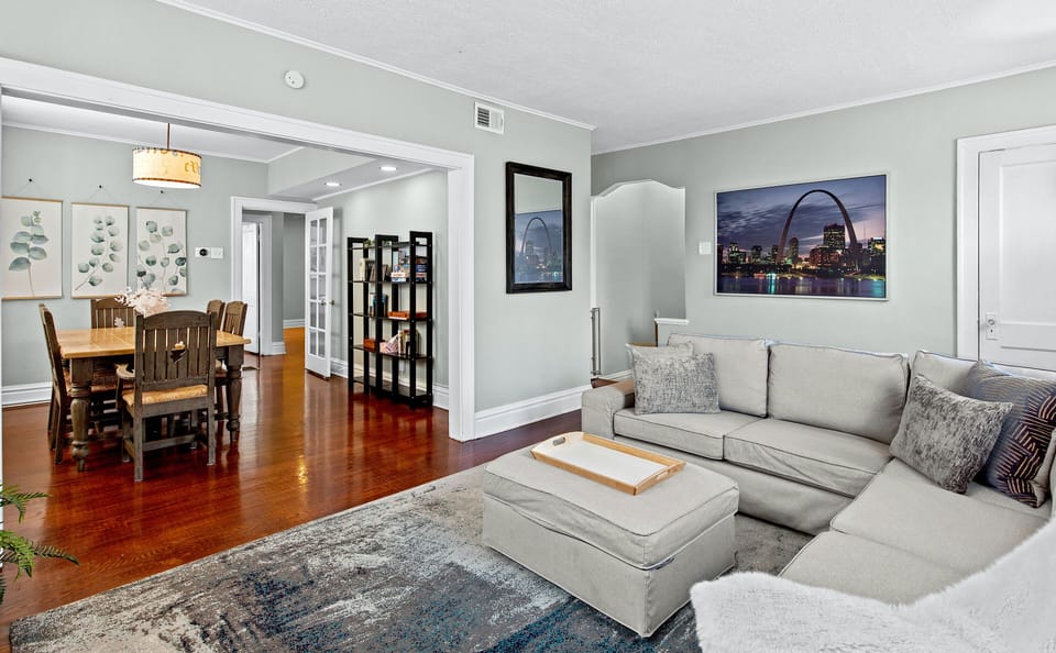 View of living room & dining room with sectional couch, welcome guide & blankets